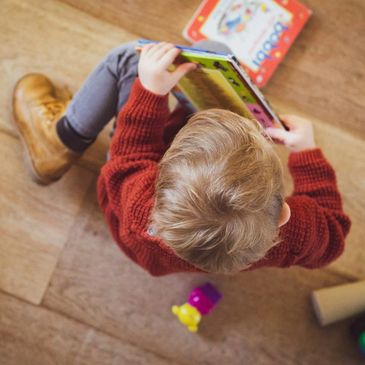 Top view of child reading a book.