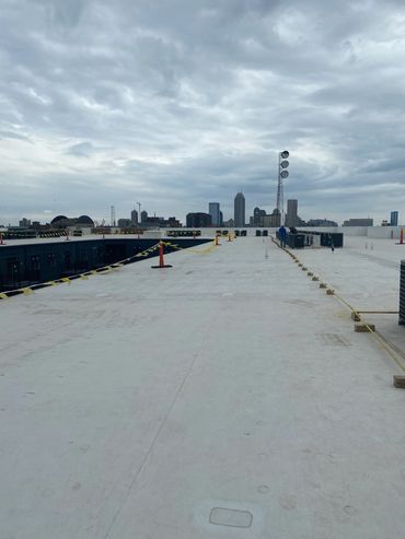 Rooftop view with city skyline in the background under cloudy sky.