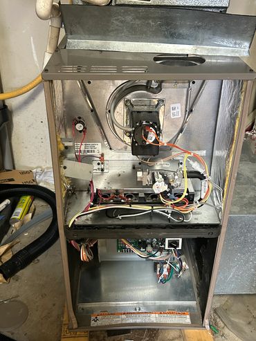 Open furnace showing internal wiring and components.