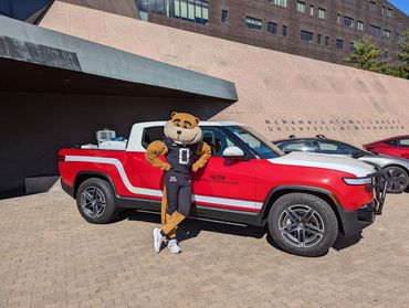 University of Minnesota Electric Symposium 2024 - Goldy Gopher standing next to electric fire truck.
