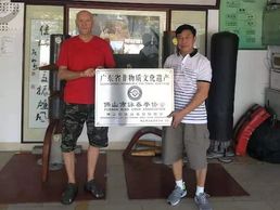 Master Lun Zhixiong presenting Derek Frearson with a plaque.
