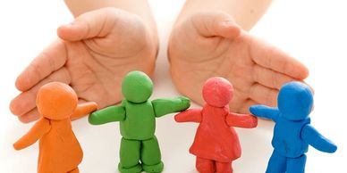 Child playing with colorful clay figures of people diverse