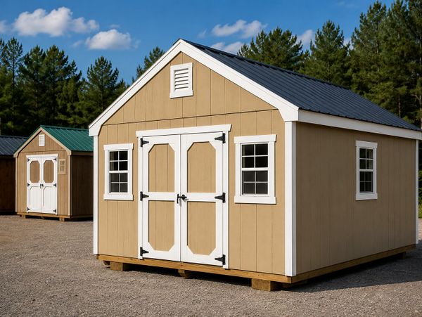 A beige storage shed with white-trimmed doors and windows on a gravel lot.