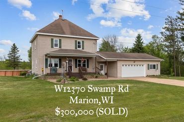 Two-story house with a large lawn and attached garage in Marion, WI, sold for $300,000.