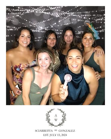 Friends laughing with a photo booth rental near me at a wedding in Westchester, NY.