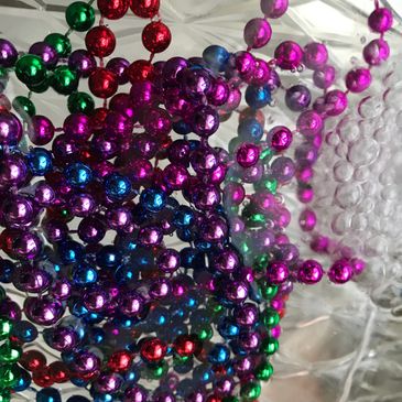 Colorful metallic beads in red, green, purple, and blue.
