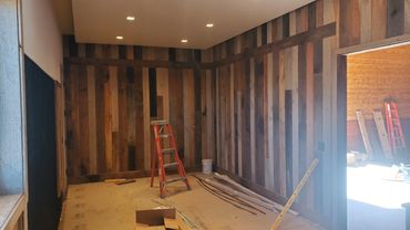 Room under construction with wooden plank walls and a ladder.