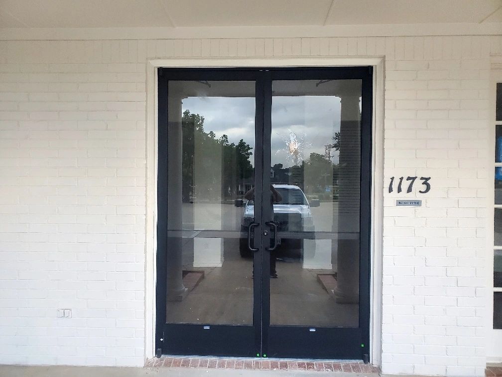 Glass storefront door on white brick building