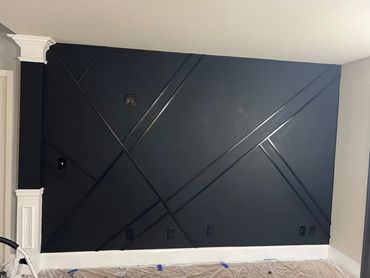 Modern black accent wall with geometric trim design.