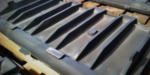 Large metal industrial casting with ribs on wooden pallets.