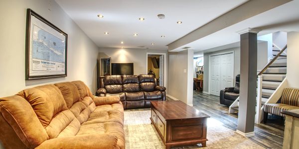 Cozy basement living room with plush sofas and a wooden coffee table.