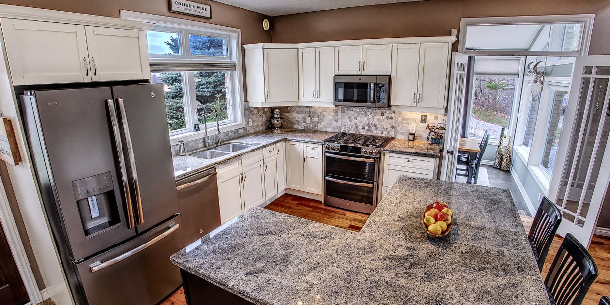 Modern kitchen with stainless steel appliances and granite countertops.