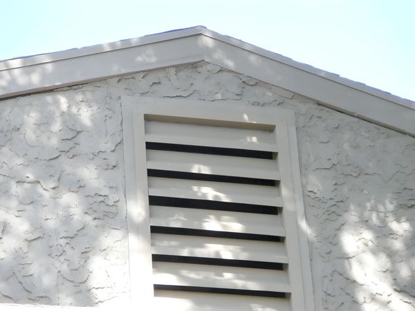 Stucco home with completed roof installation and vent repairs.