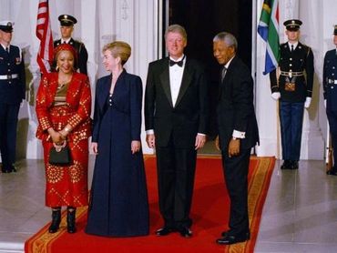 The Mandela's meet on the red carpet with the Clinton's for an official state dinner.