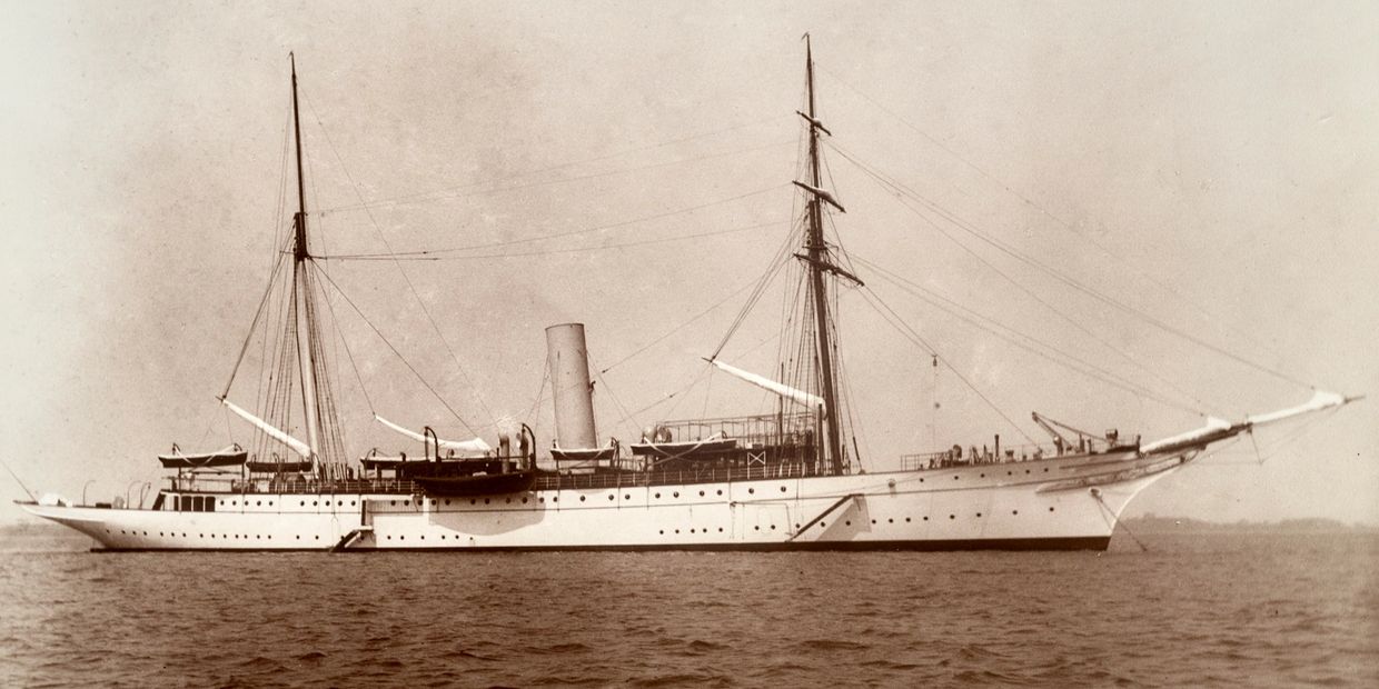 A black and white, sepia style photo of the USS Mayflower.
