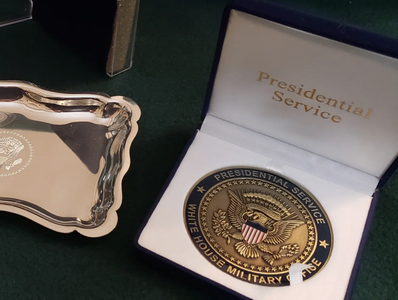 US Presidential Service Center gold coin with white silk and gold foil lettering in a blue felt box.