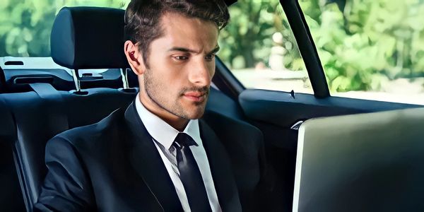 a business man working in his laptop while in a luxury vehicle