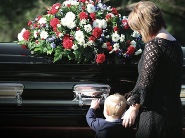Mother with toddler at father's casket