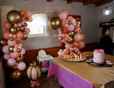 Gold, peach, and matte pink round balloon arch. First birthday celebration.