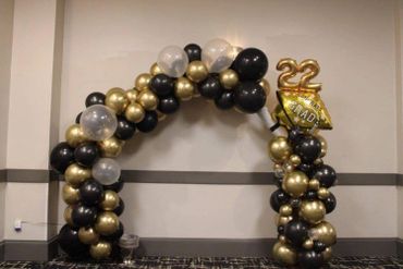 Graduation balloon garland in black, gold, and clear confetti balloons.