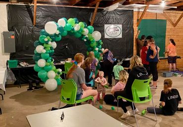 Linden 4H group working with Kalei to build a green and white balloon arch for their display.