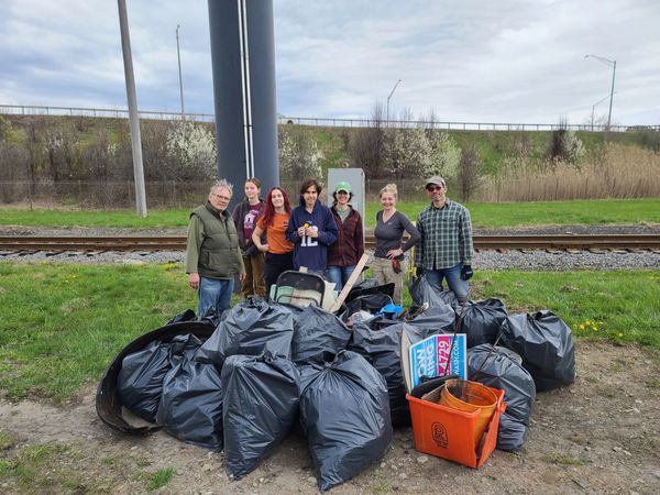 people psing with bags of garbage for a cleanup