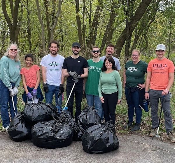 group posing with bags of garbage
