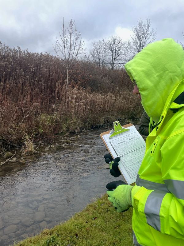 Samantha with a clipboard at a culvert