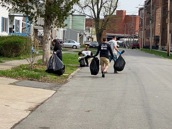 man waking with 2 bags of garbage during a cleanup