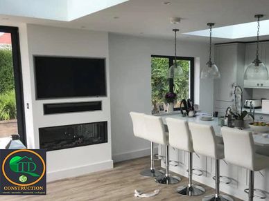Modern kitchen with breakfast bar/feature Island, recessed TV and feature fire by TD the Isle of Man