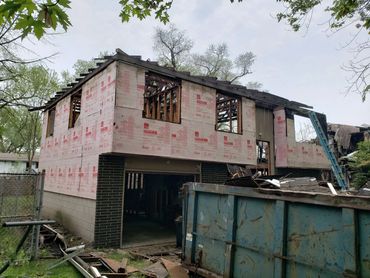 House under construction with exposed insulation and wood framing.