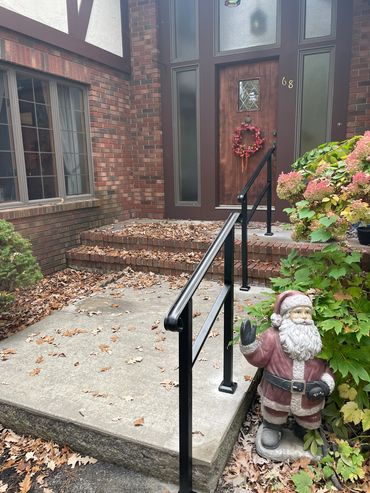 Front porch with a Santa statue and autumn leaves scattered around.