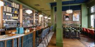 Cozy bar interior with green walls and wooden floors.
