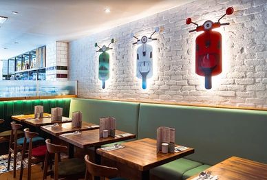 Modern restaurant interior with colorful robot wall art and wooden tables.