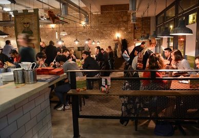 Busy restaurant interior with people dining and socializing.