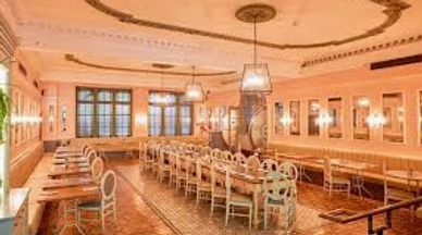 Elegant dining room with vintage decor and long wooden tables.