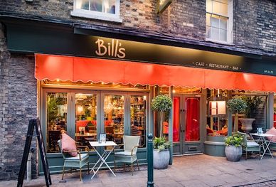 Cozy outdoor seating at Bill's café with warm lighting and greenery.