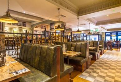 Cozy restaurant with vintage leather booths and warm lighting.
