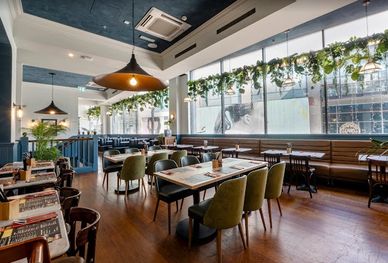 Modern cafe interior with green chairs and natural lighting.