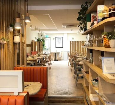 Cozy modern restaurant interior with wooden accents and orange seating.