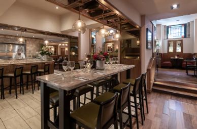 Elegant dining area with marble table, pendant lights, and comfortable seating.