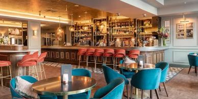 Stylish bar interior with teal chairs and copper tables.