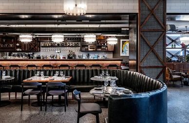 Elegant restaurant interior with a curved leather banquette and modern lighting.