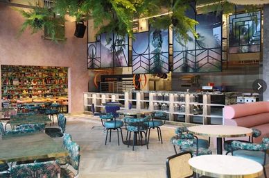 Modern café interior with colorful chairs and artistic wall decor.