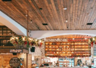 Cozy café interior with wooden ceiling and festive decorations.