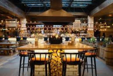 Cozy restaurant interior with wooden tables and warm lighting.