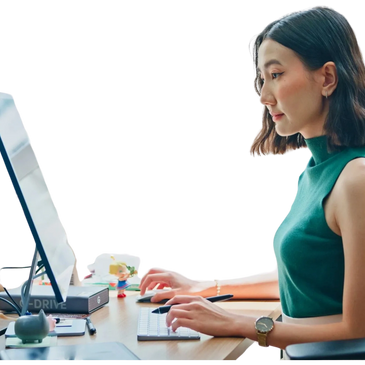 Woman working on a computer at a desk, focused and engaged.