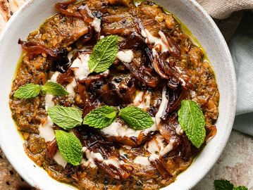 Baba ganoush topped with caramelized onions, tahini, and fresh mint leaves.