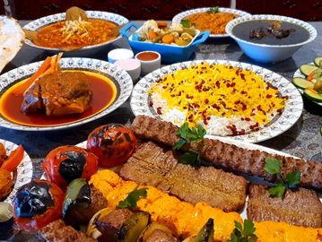 A lavish Persian feast with kebabs, saffron rice, grilled tomatoes, and various side dishes.