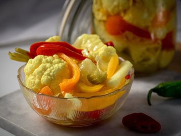 A bowl of colorful pickled vegetables including cauliflower and peppers.